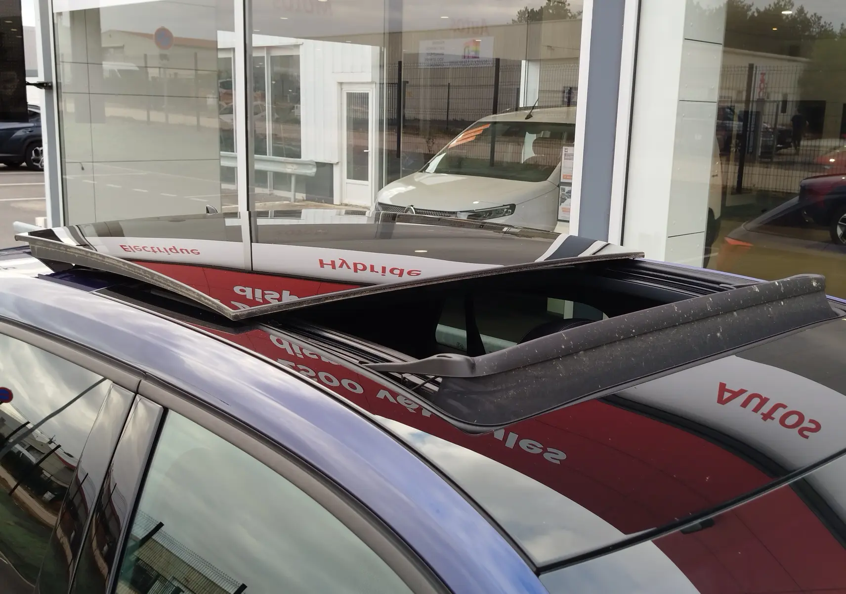 Toit ouvrant relevé vu de dessus sur un Audi Q2 bleu Navarre, mettant en valeur la finition S line 2023.