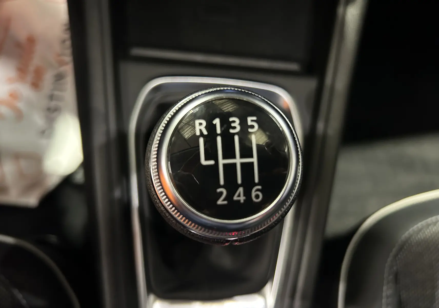 Gros plan sur le levier de vitesses manuel du Renault Captur 2024, montrant les six rapports et la marche arrière.