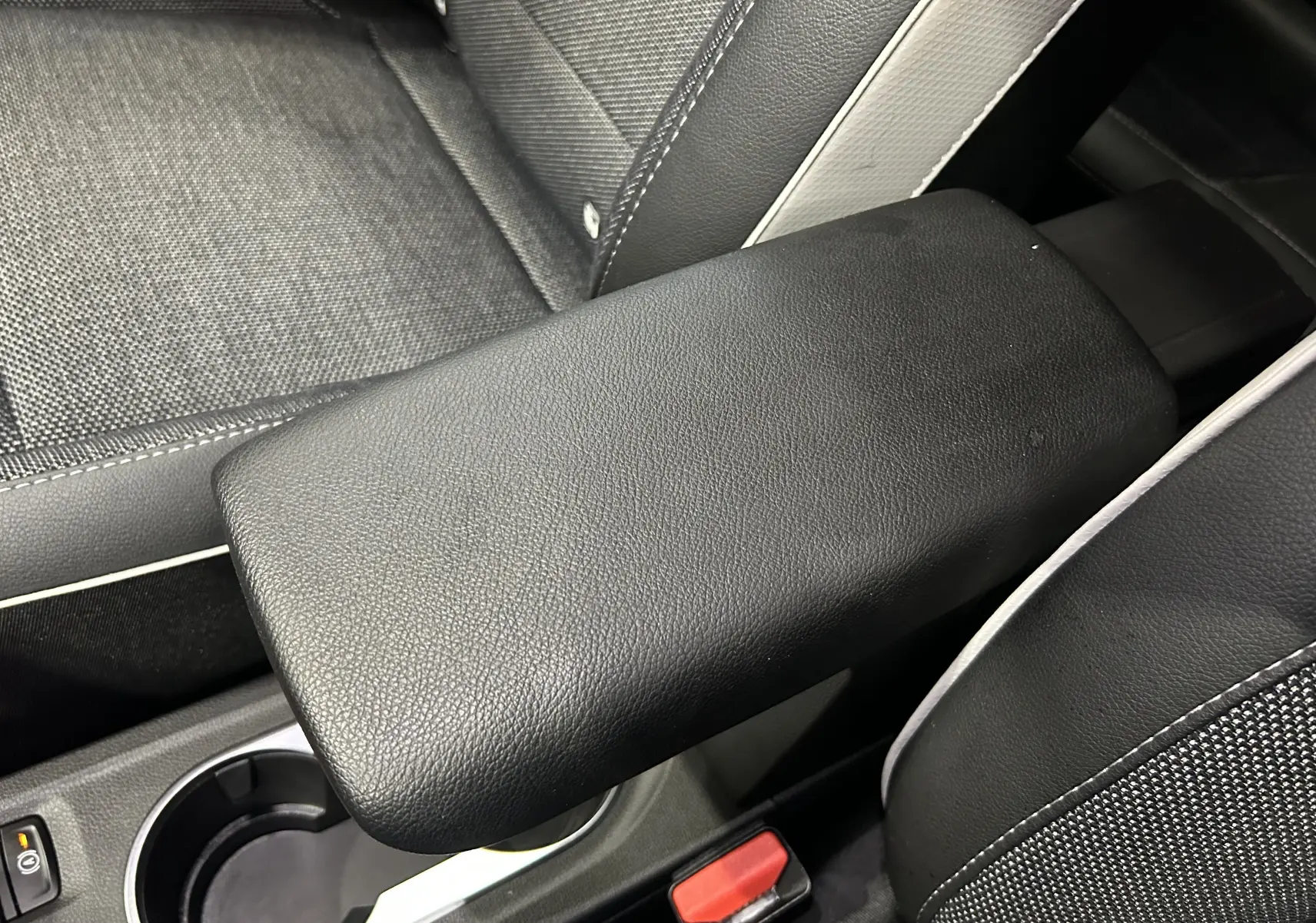 Accoudoir central en cuir noir avec surpiqûres blanches, siège tissu et cuir dans Renault Captur TCE 90CH 2024.