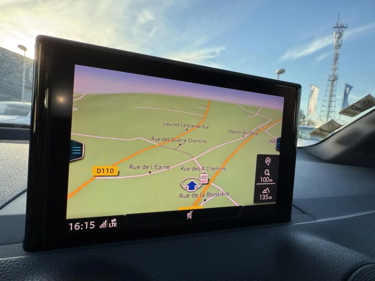 Écran de navigation MMI de l'Audi Q2 noir brillant, affichant une carte routière en intérieur véhicule.