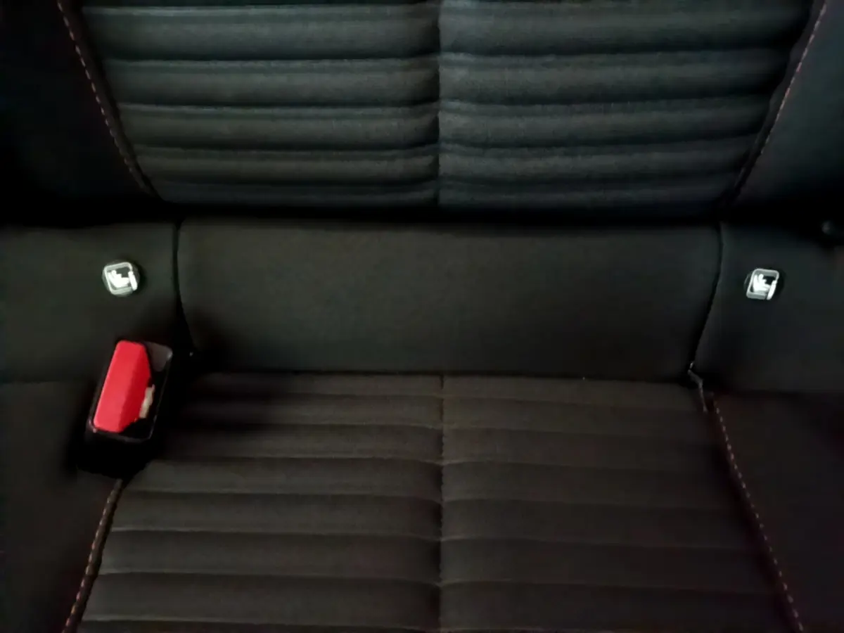 Gros plan sur la banquette arrière noire de la Peugeot 208 Electrique Active Business avec ceintures et fixation Isofix visibles.