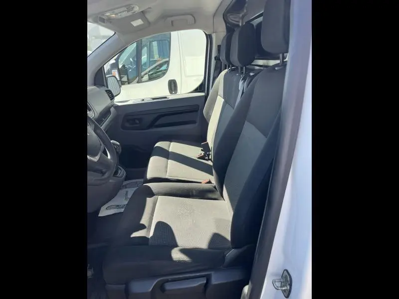 Vue intérieure côté droit montrant les sièges avant noirs du Citroën Jumpy blanc banquise, version Business 2018.