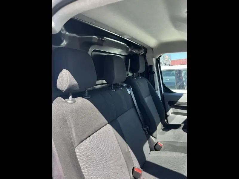 Vue intérieure côté droit montrant la banquette avant noire du Citroën Jumpy M 1.6 BlueHDi 2018 avec cloison tôlée arrière.