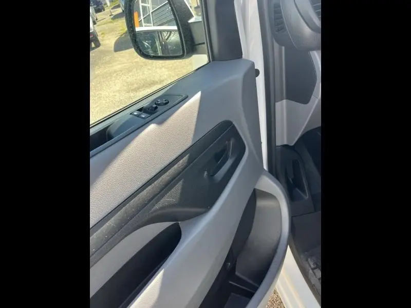 Vue rapprochée de la porte avant gauche blanche banquise du Citroën Jumpy avec commandes des vitres et rétroviseur.