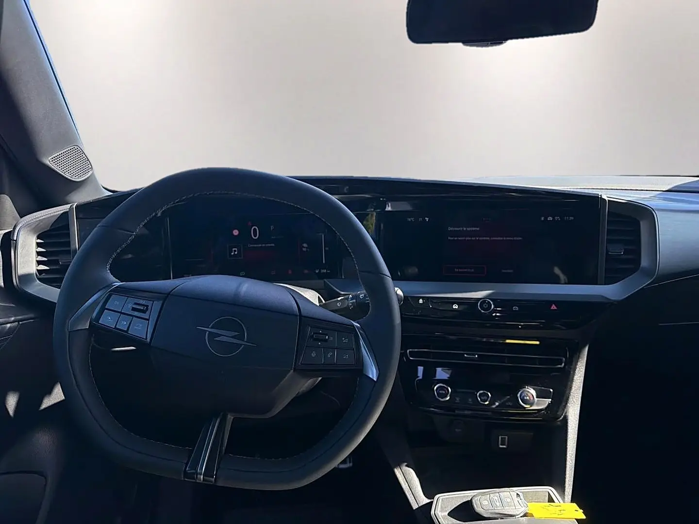 Vue intérieure centrée sur le volant multifonction et l'écran tactile du tableau de bord de l'Opel Mokka Electric gris.