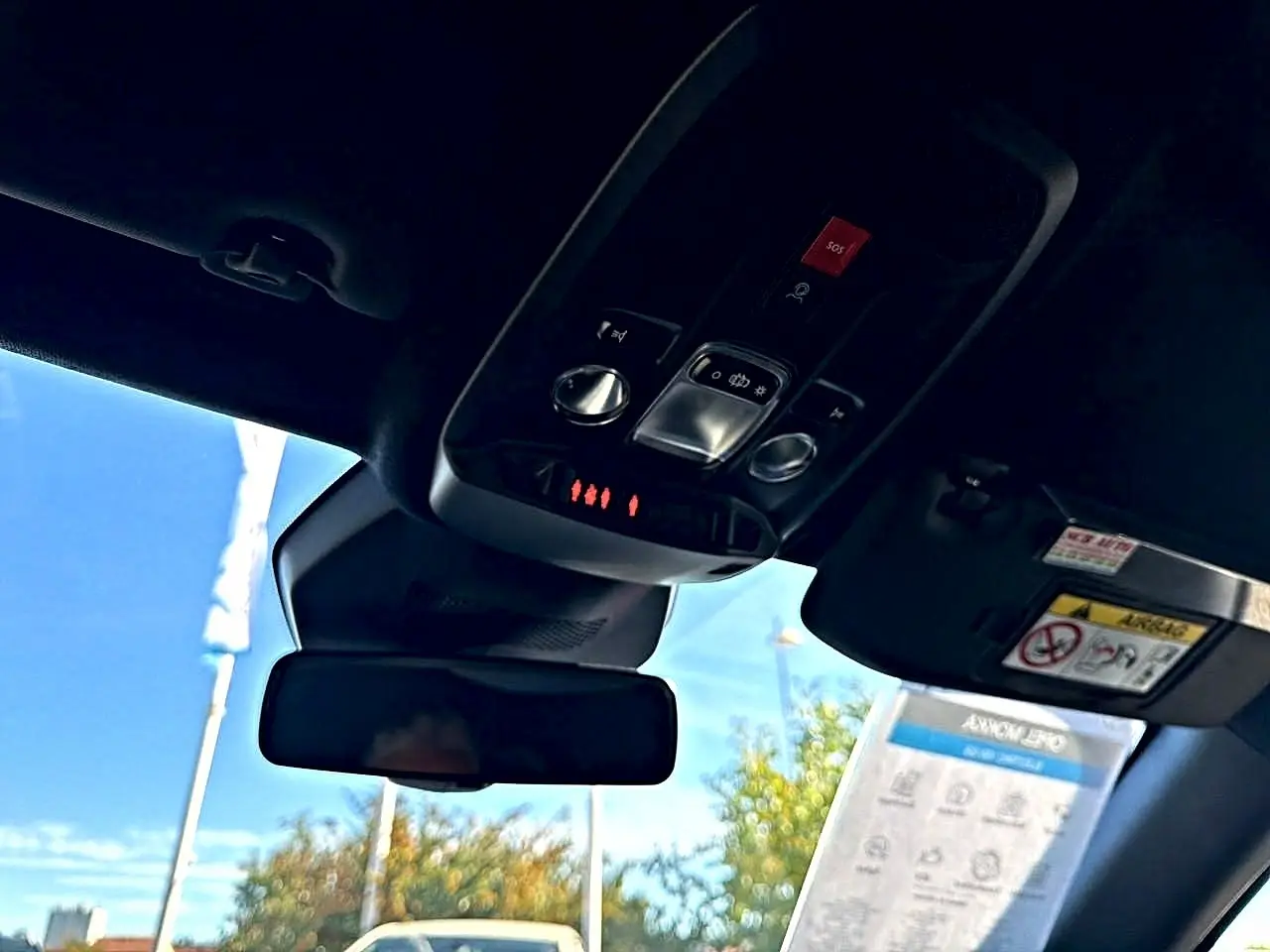 Vue intérieure du toit ouvrant et du panneau de commandes avec bouton SOS d'un Opel Mokka Electric gris 2025.