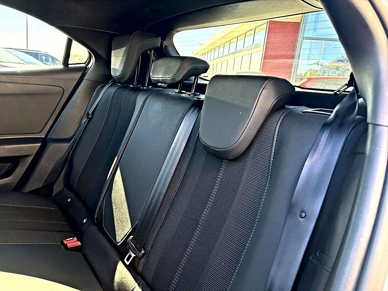Vue intérieure des sièges arrière noirs de l'Opel Mokka Electric 156 gs 2025, avec appuie-têtes et ceintures visibles.