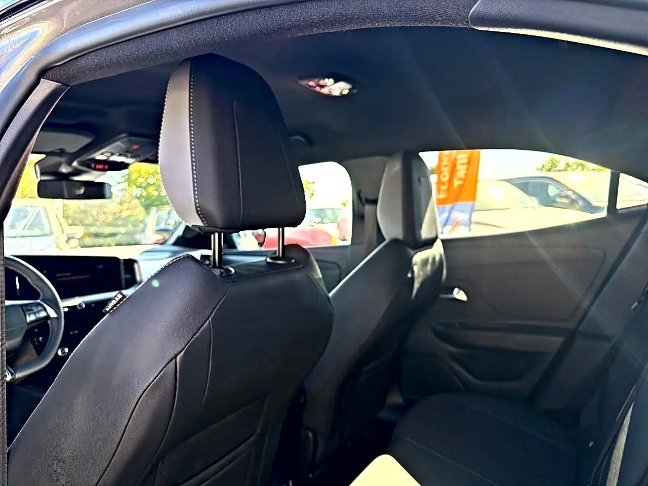 Vue intérieure arrière droite de l’Opel Mokka Electric 156 GS 2025 gris, sièges noirs et tableau de bord partiel visible.