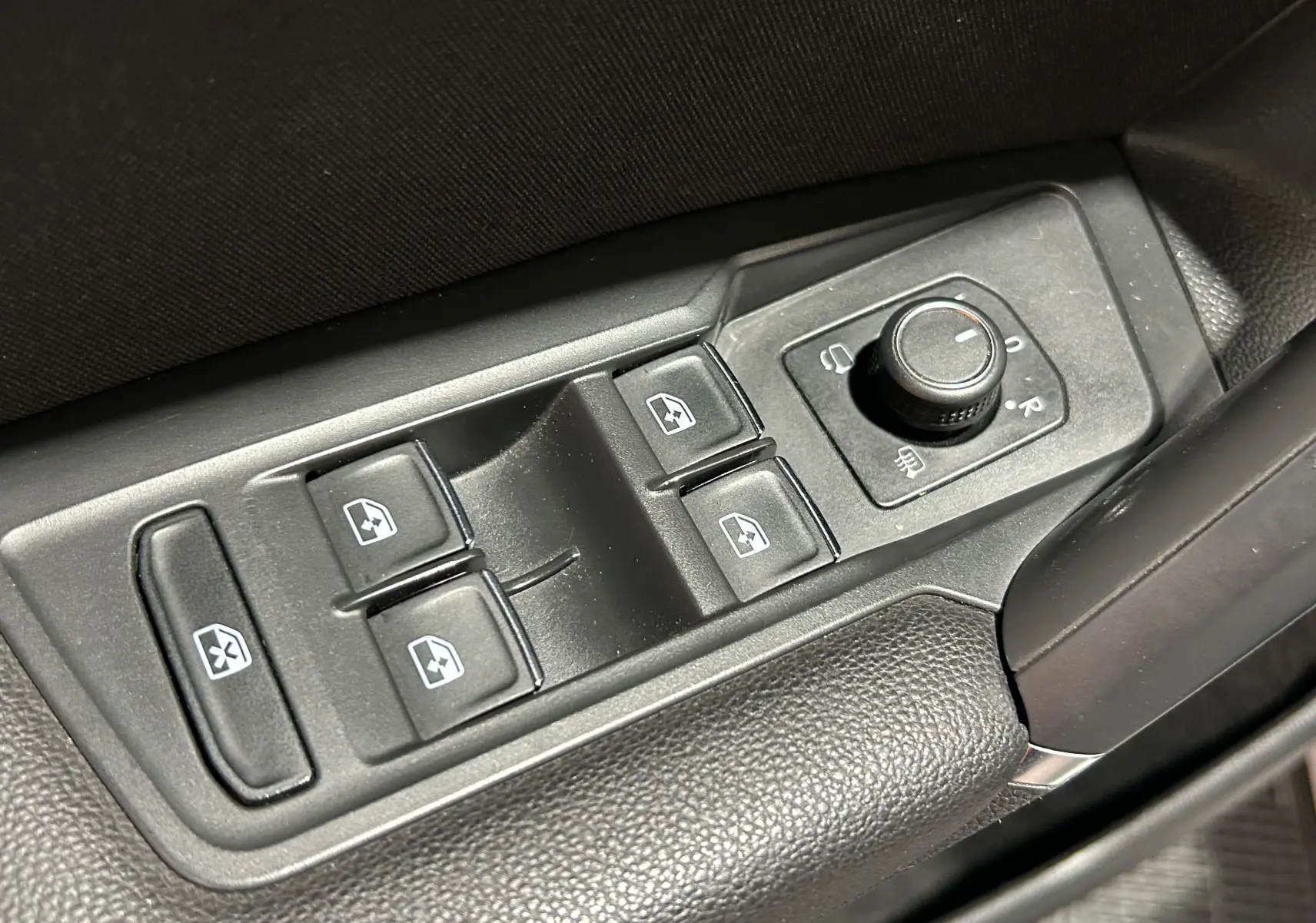 Gros plan sur les commandes des vitres et rétroviseurs côté conducteur du Volkswagen Tiguan Allspace blanc de 2018.