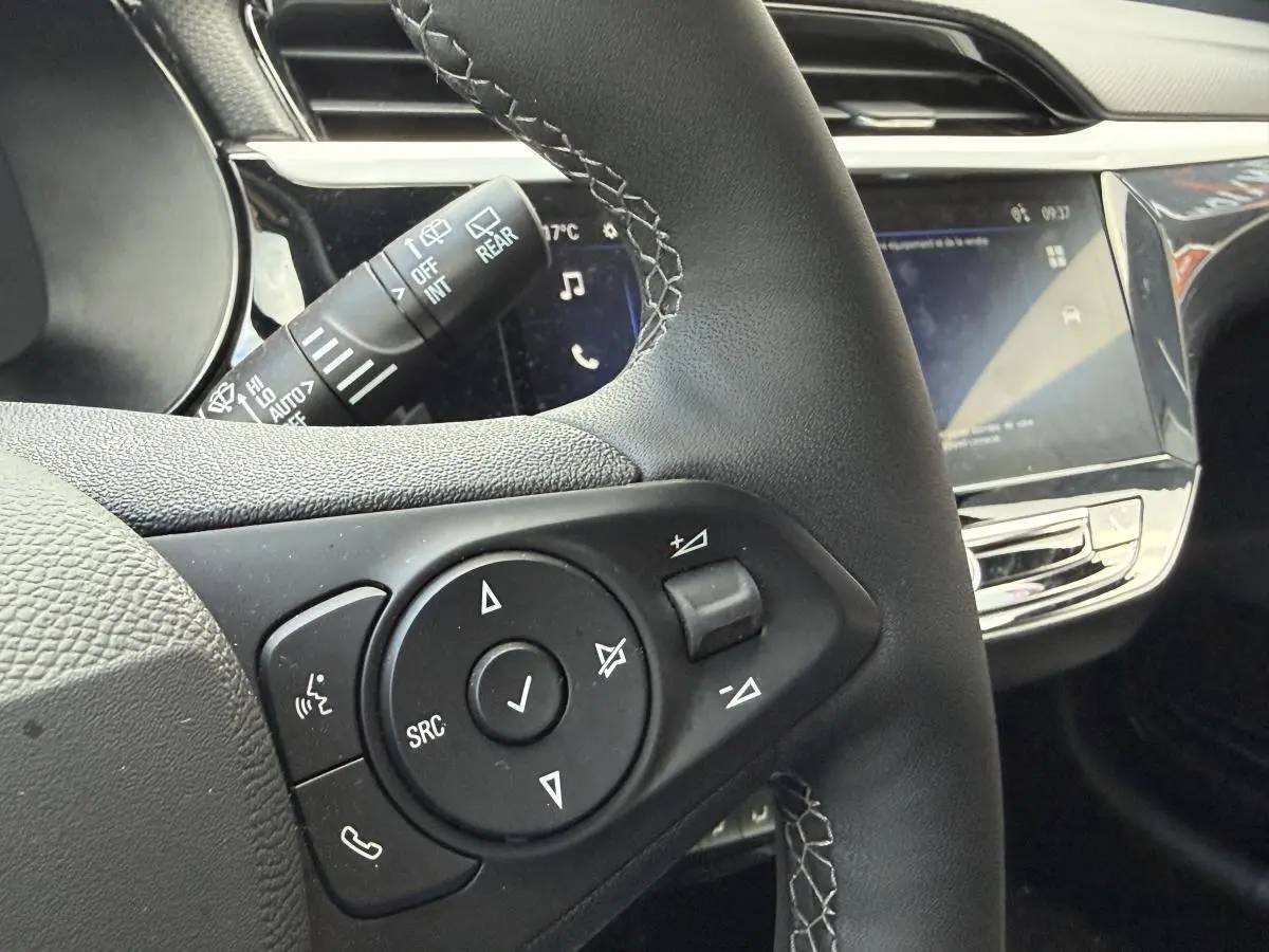 Gros plan sur le volant noir multifonction et la console centrale brillante de l'Opel Corsa 2024.