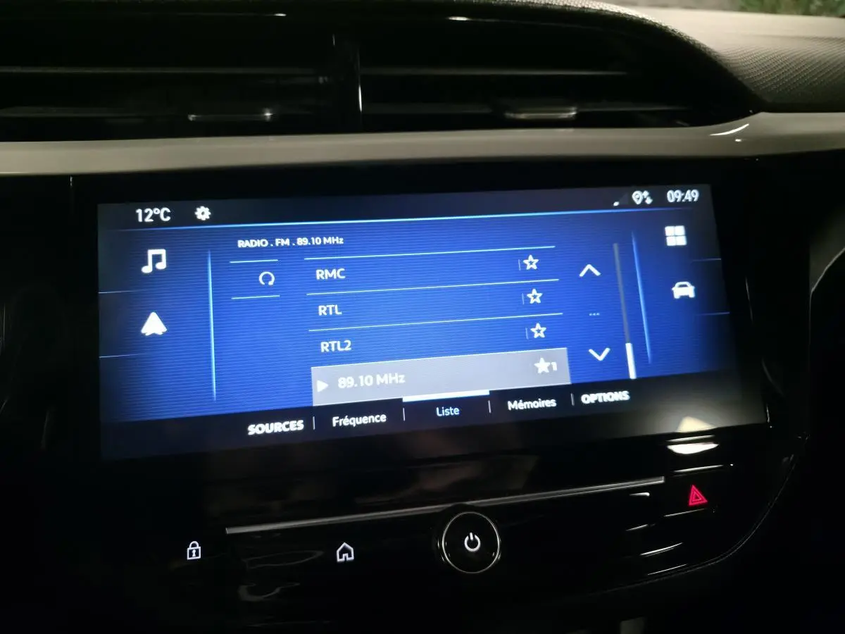 Écran tactile central de la console d'une Opel Corsa noire affichant les stations radio FM à 89,10 MHz.
