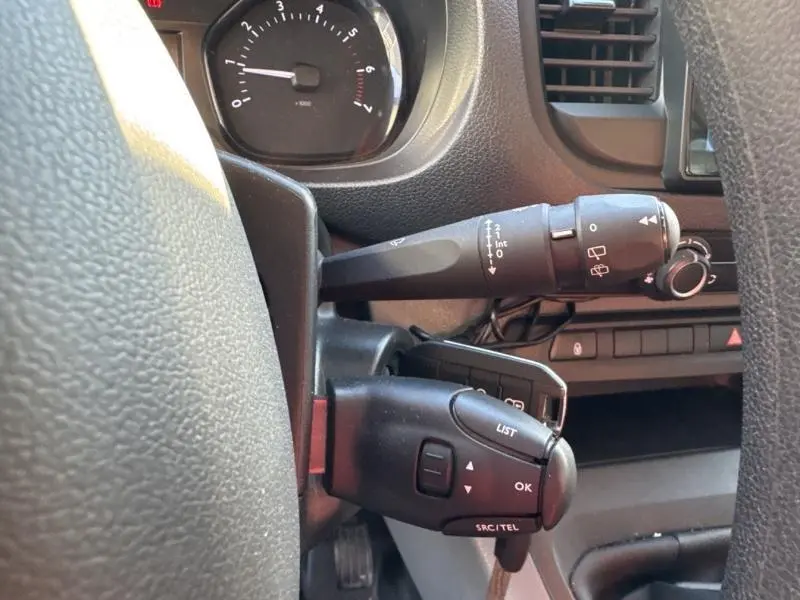 Gros plan sur la commande de clignotants et régulateur de vitesse du tableau de bord du Citroën Jumpy blanc Banquise.