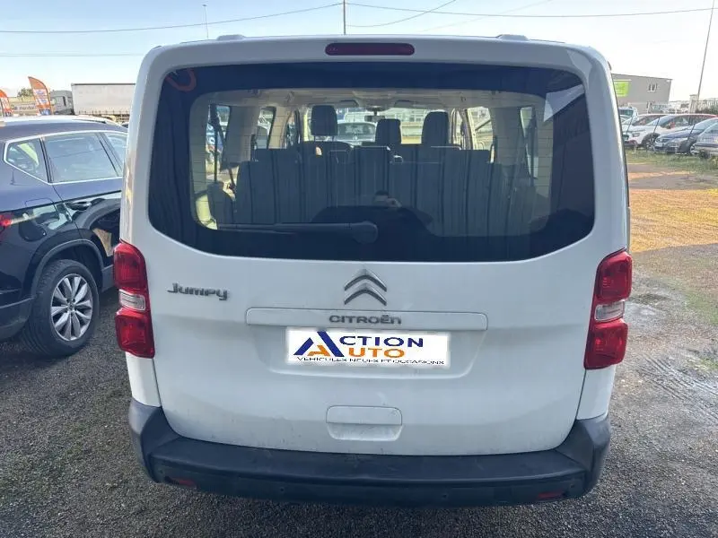Vue arrière d'un Citroën Jumpy XL blanc Banquise avec portes battantes et vitres teintées, stationné en extérieur.
