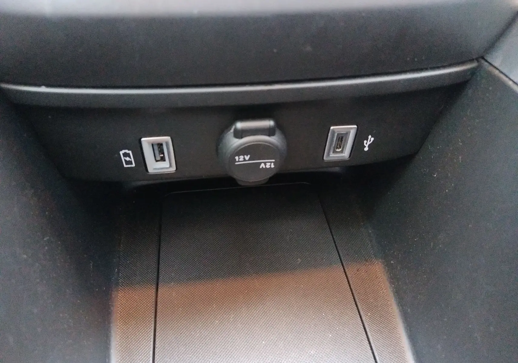 Vue rapprochée de la console centrale du Jeep Avenger eHYBRID avec prises USB et prise 12V visibles.