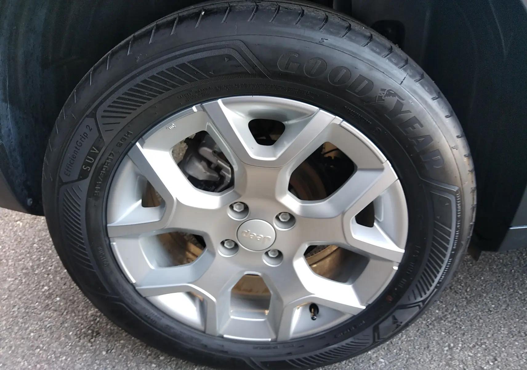 Gros plan sur la jante argentée à 6 branches du Jeep Avenger eHYBRID gris, équipée d’un pneu Goodyear.
