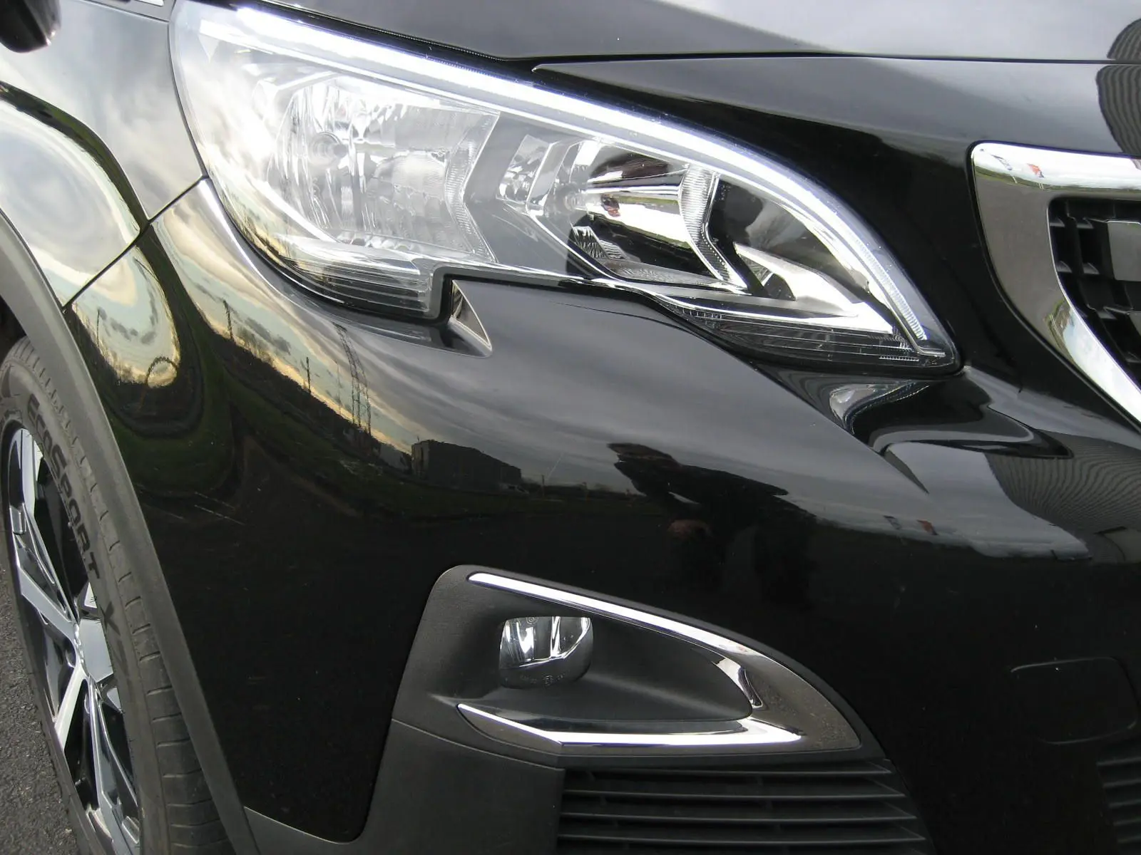 Gros plan sur l'avant droit noir du Peugeot 3008 2020, mettant en valeur le phare et le feu antibrouillard chromé.
