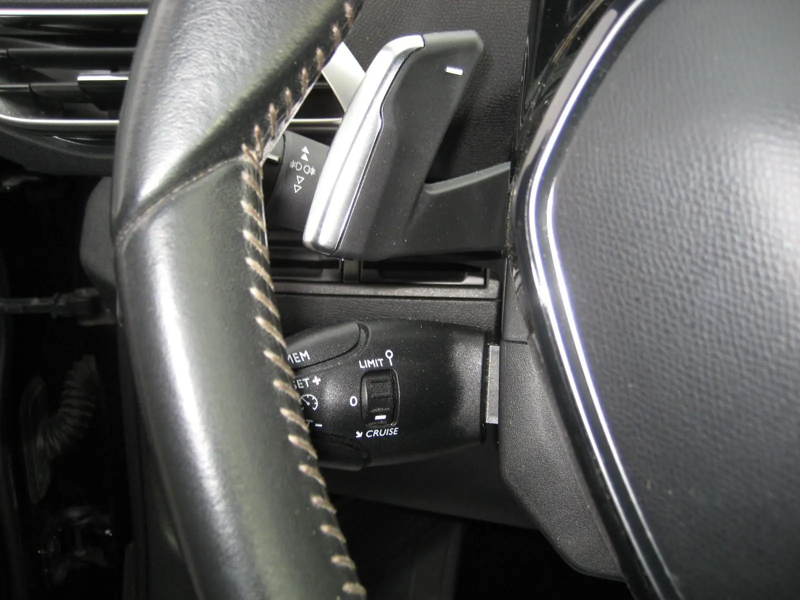 Gros plan sur la commande de régulateur de vitesse et levier de vitesses au volant du Peugeot 3008 noir Business 2020.