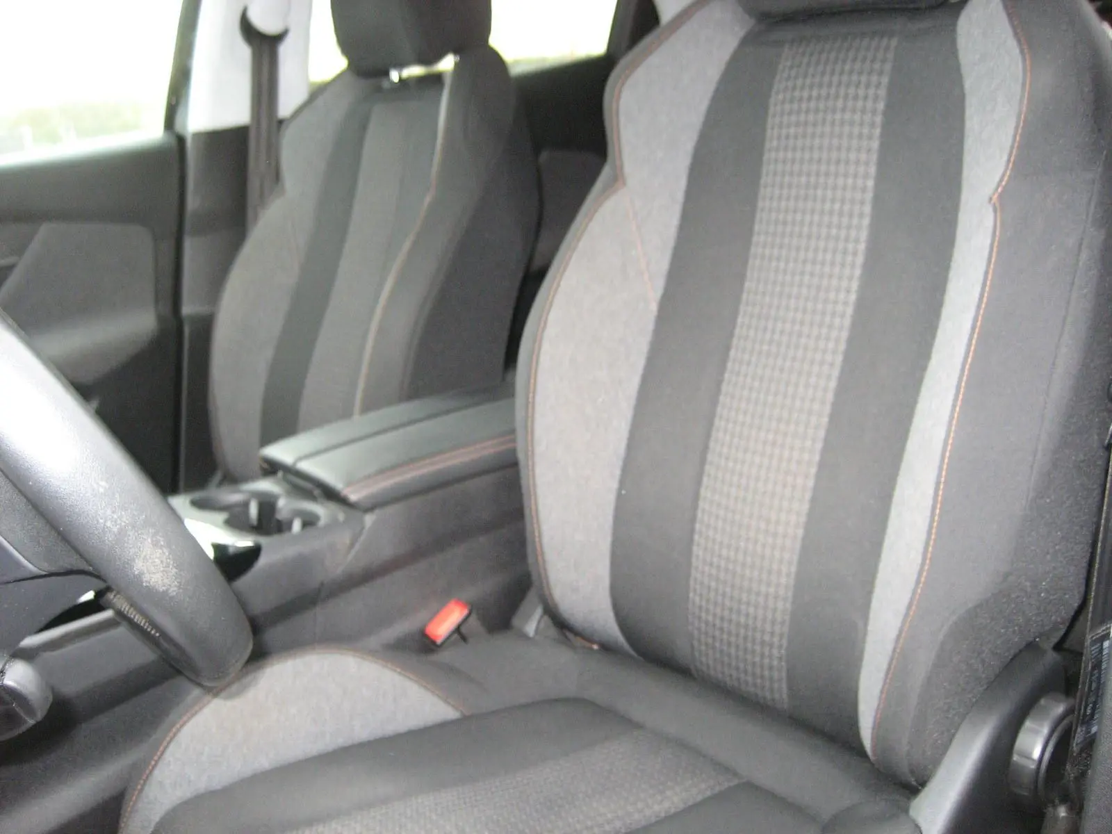 Intérieur du Peugeot 3008 Business 2020, vue rapprochée des sièges avant en tissu gris avec surpiqûres orange.