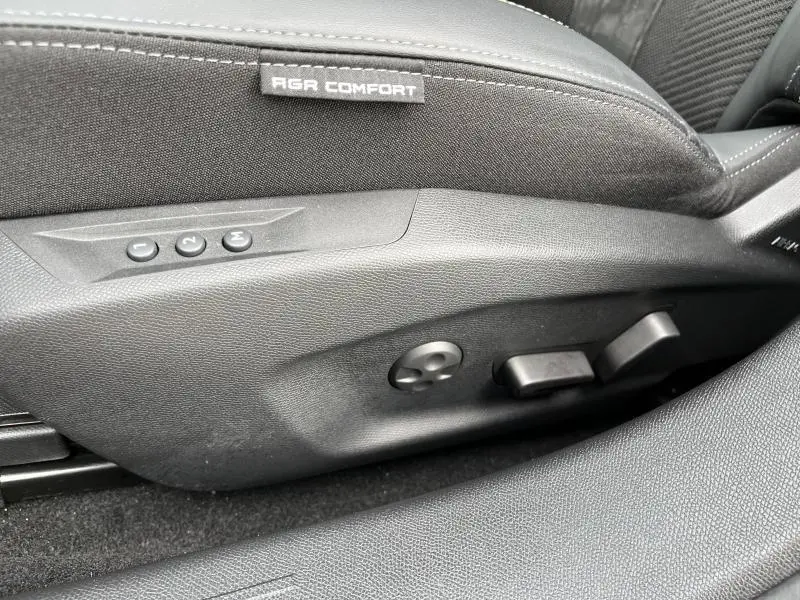 Gros plan sur les commandes de réglage électrique du siège conducteur noir du Peugeot 308 SW 2023 finition GT.