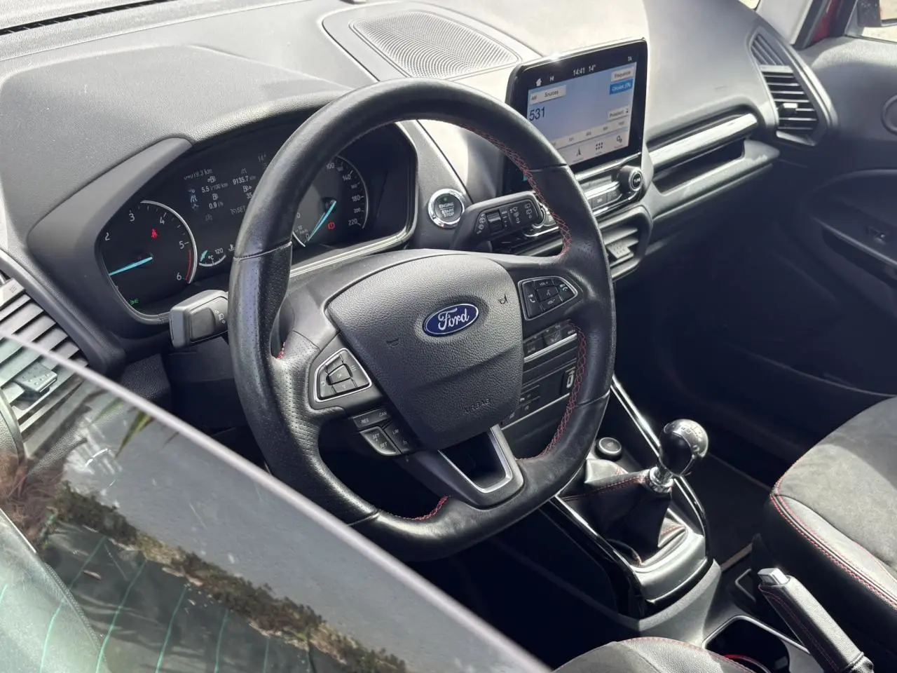 Intérieur du Ford EcoSport ST-Line 2019, vue côté conducteur sur le volant cuir perforé et la console centrale.