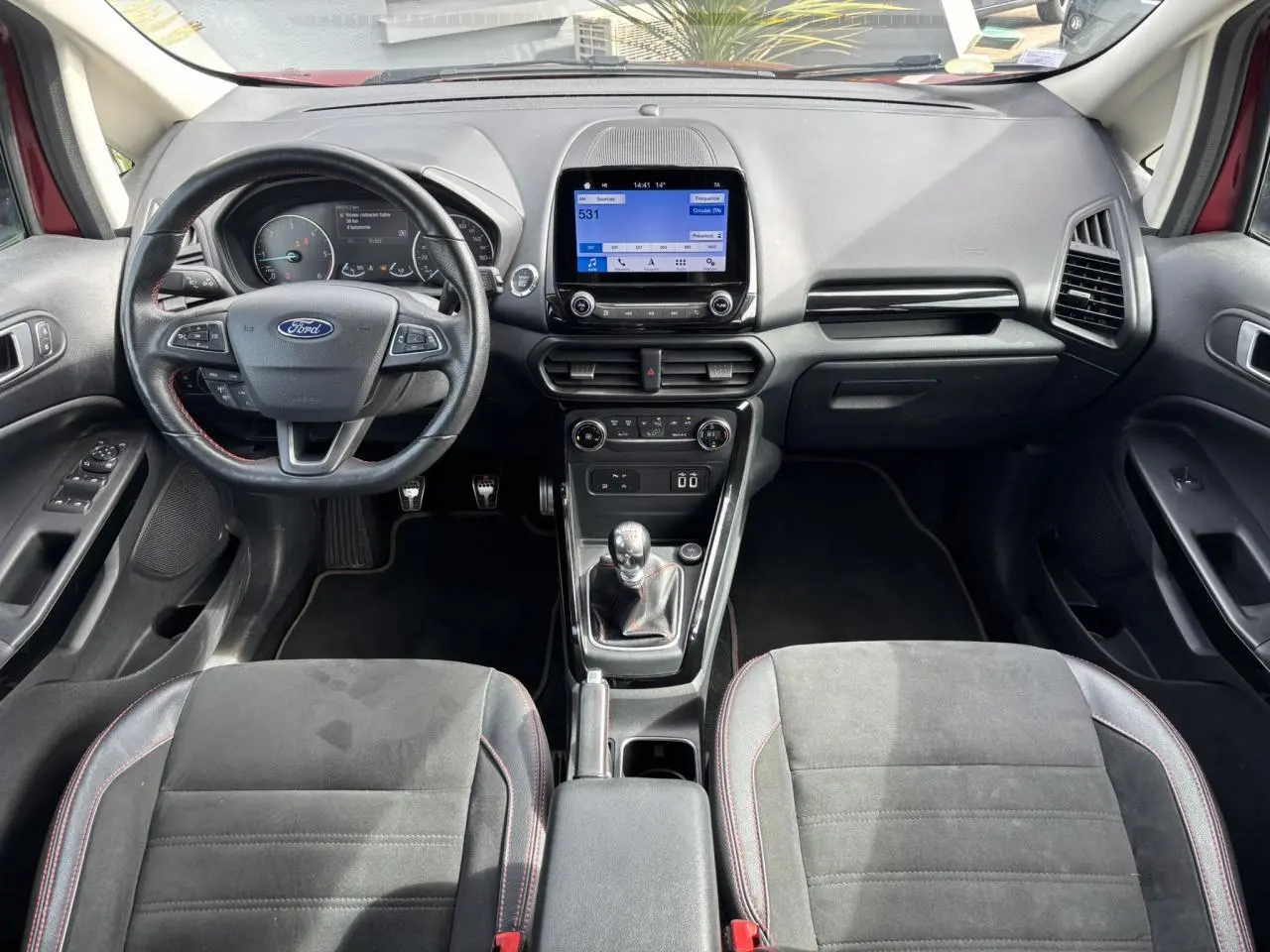 Intérieur avant du Ford EcoSport rouge 2019, tableau de bord avec écran tactile et volant cuir ST-Line.