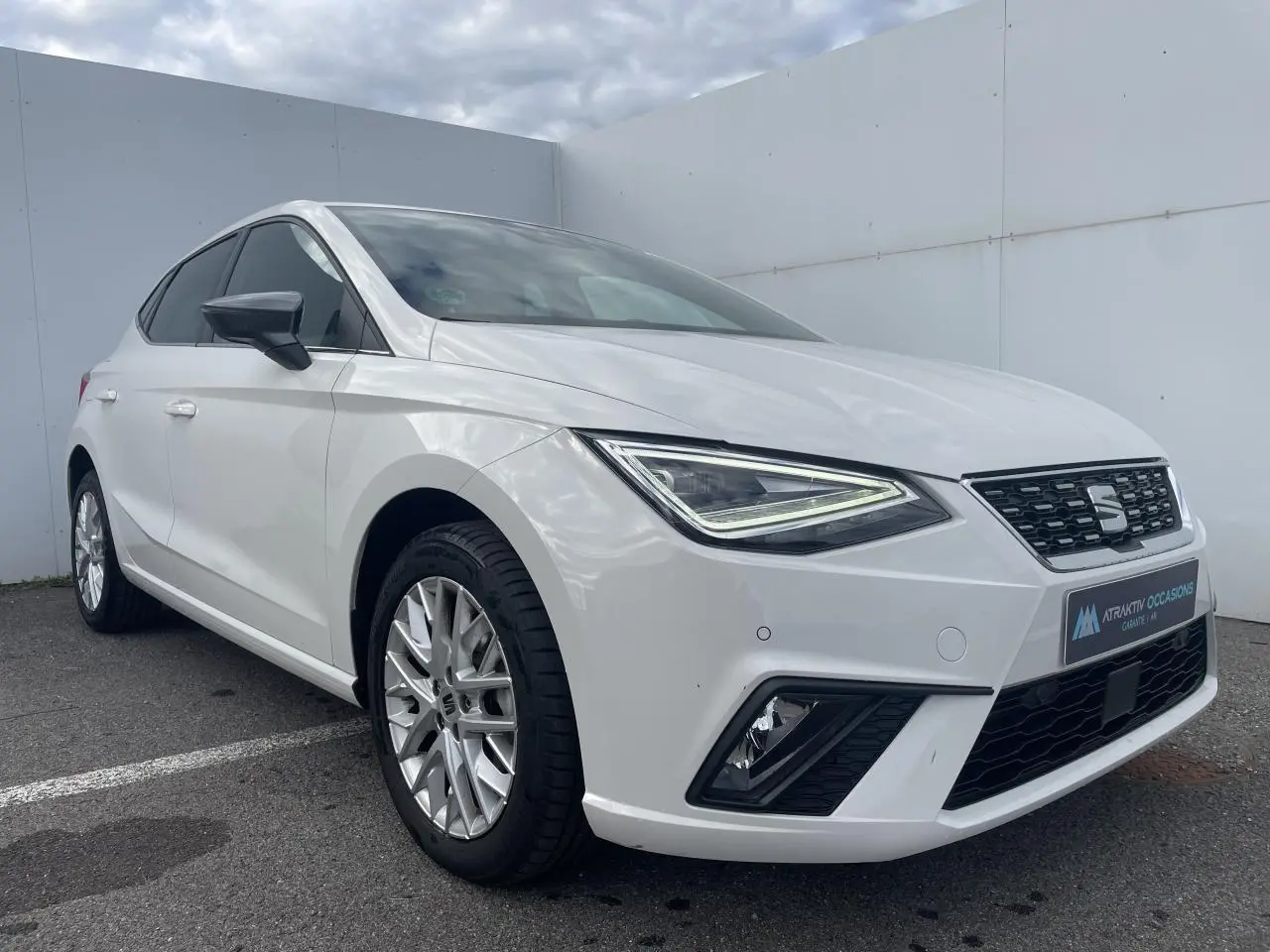 SEAT Ibiza blanche vue en 3/4 avant droit, avec jantes alliage et feux LED à signature triangulaire.