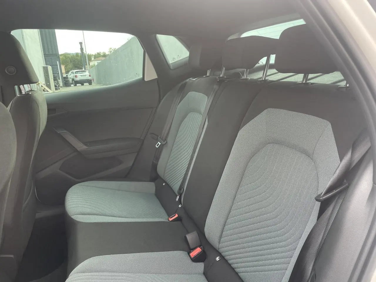 Vue intérieure côté droit sur la banquette arrière en tissu gris et noir d'une SEAT IBIZA blanche 2025.