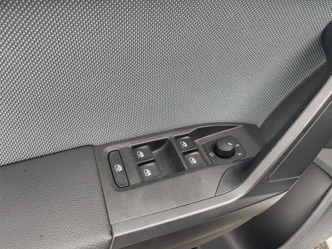 Panneau de porte côté gauche avec commandes des vitres et réglage des rétroviseurs d'une SEAT IBIZA blanche 2025.