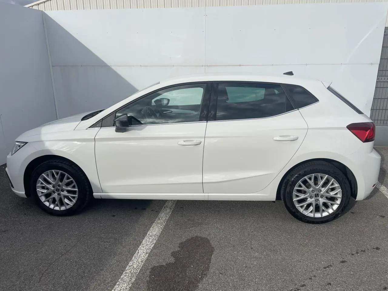 Profil côté gauche d'une SEAT Ibiza blanche 2025 avec jantes alliage et vitres surteintées arrière.