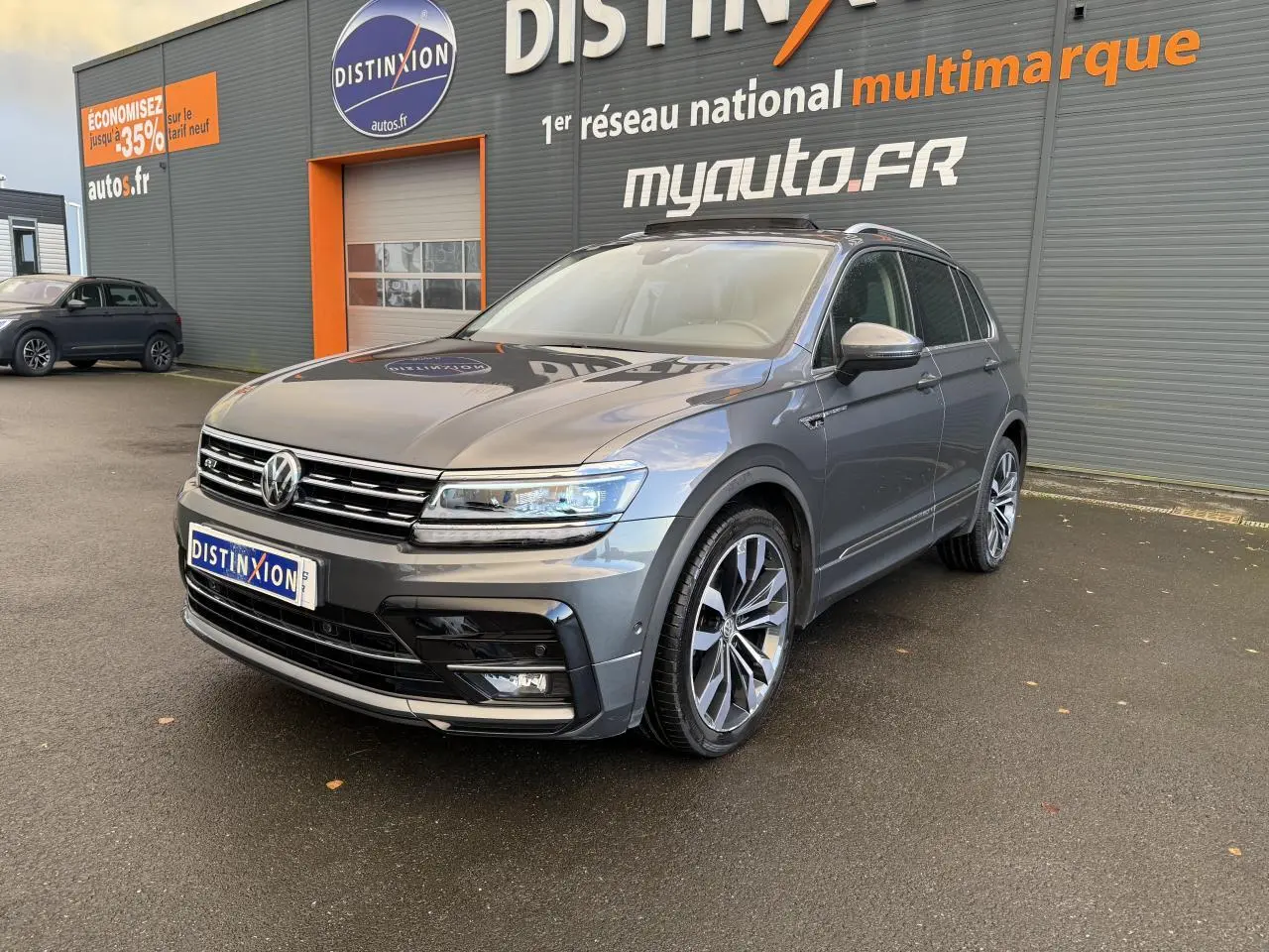 Volkswagen Tiguan gris Indium métallisé vu en 3/4 avant droit avec jantes alliage et calandre R-Line.