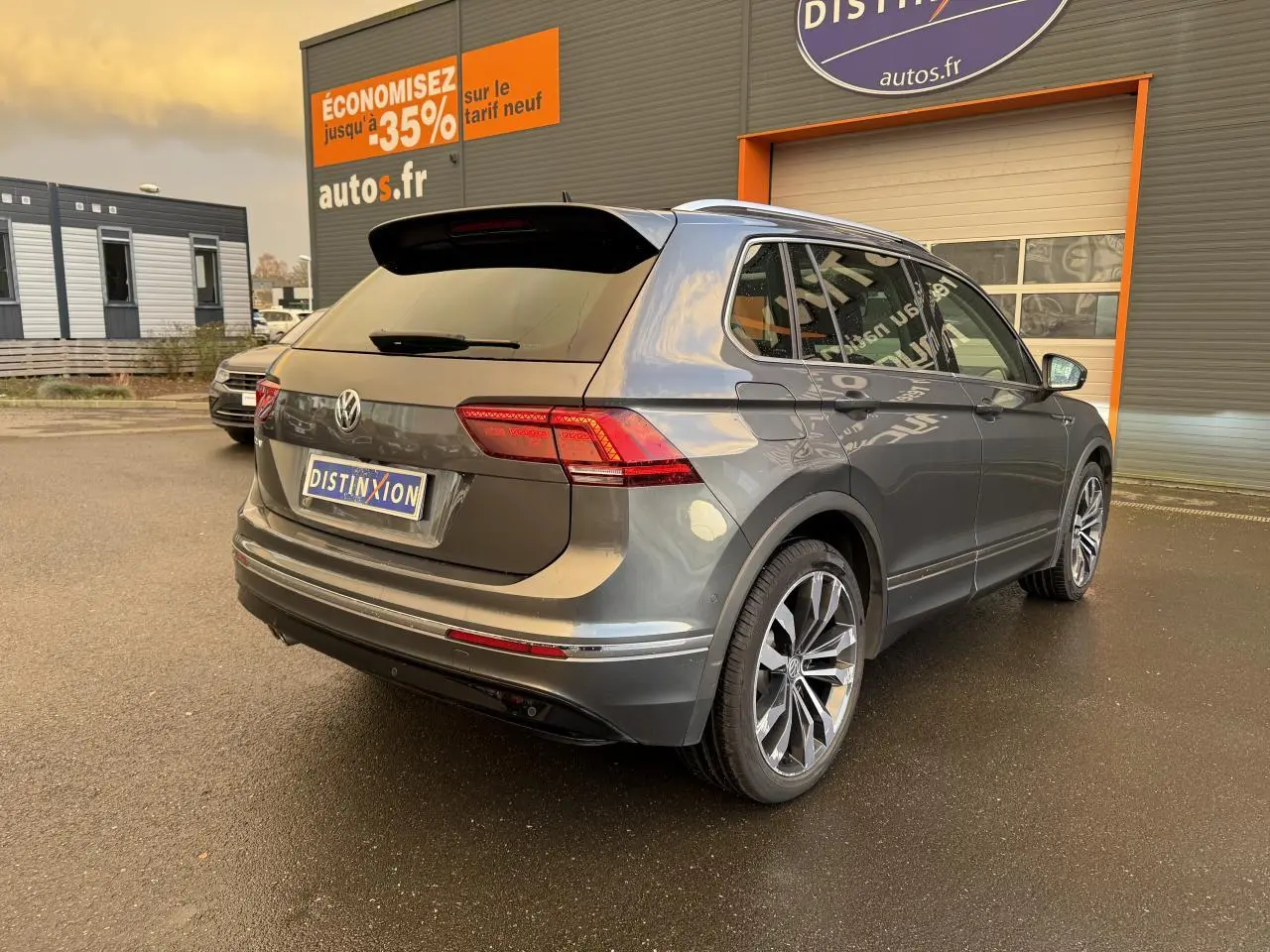 Volkswagen Tiguan gris Indium métallisé vu en 3/4 arrière droit, avec jantes alliage et feux arrière LED.