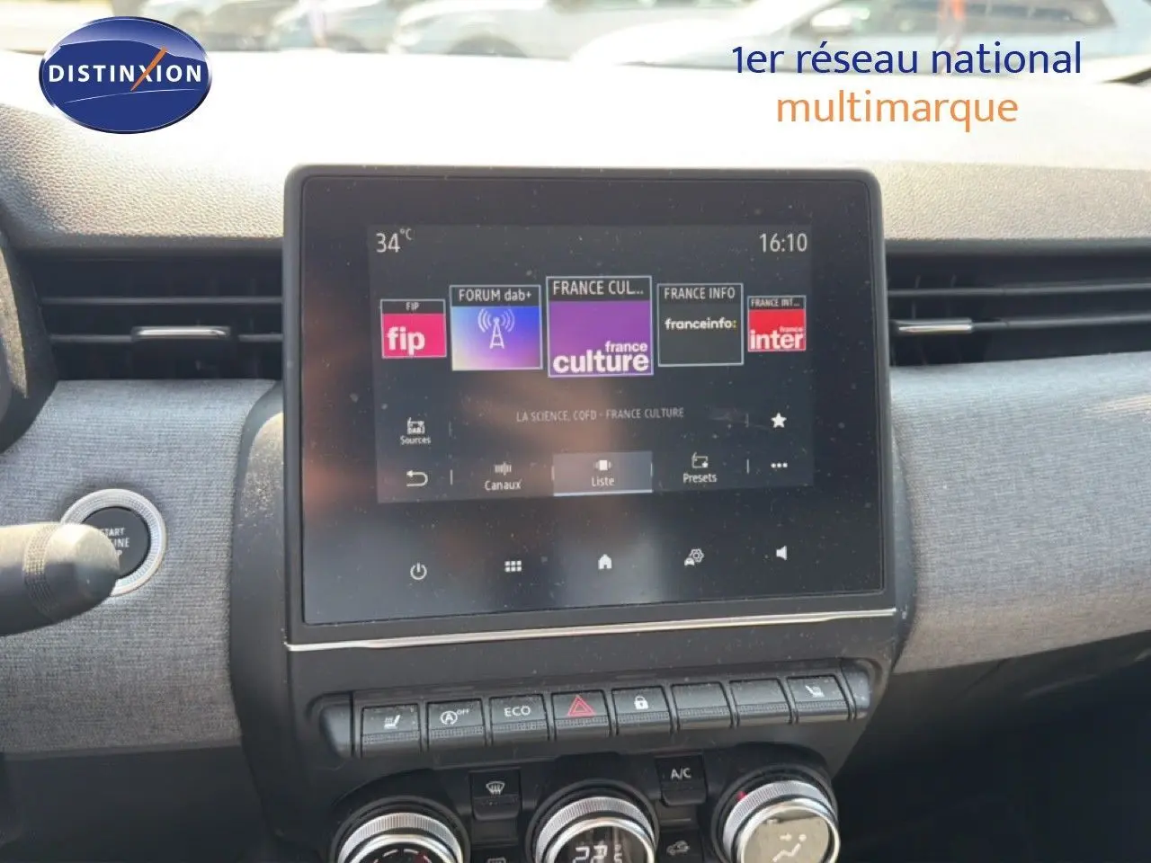 Vue rapprochée de l’écran tactile central et des commandes de la Renault Clio V rouge flamme, intérieur moderne et fonctionnel.