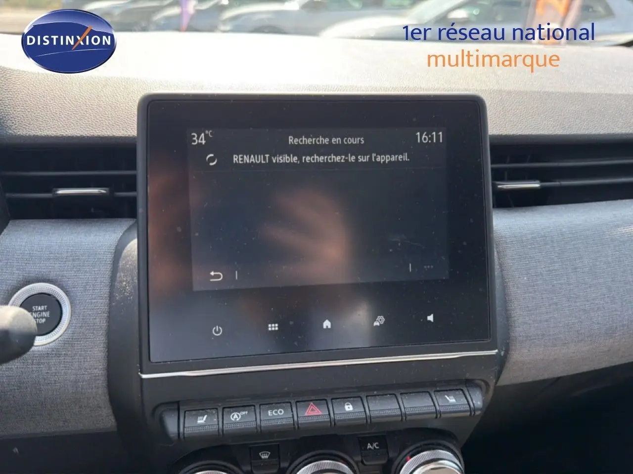 Vue rapprochée de l’écran tactile central et des commandes du tableau de bord de la Renault Clio V rouge flamme 2023.