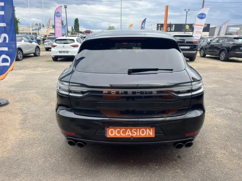 Vue arrière d'un Porsche Macan noir avec feux arrière LED teintés et double sortie d'échappement sport.