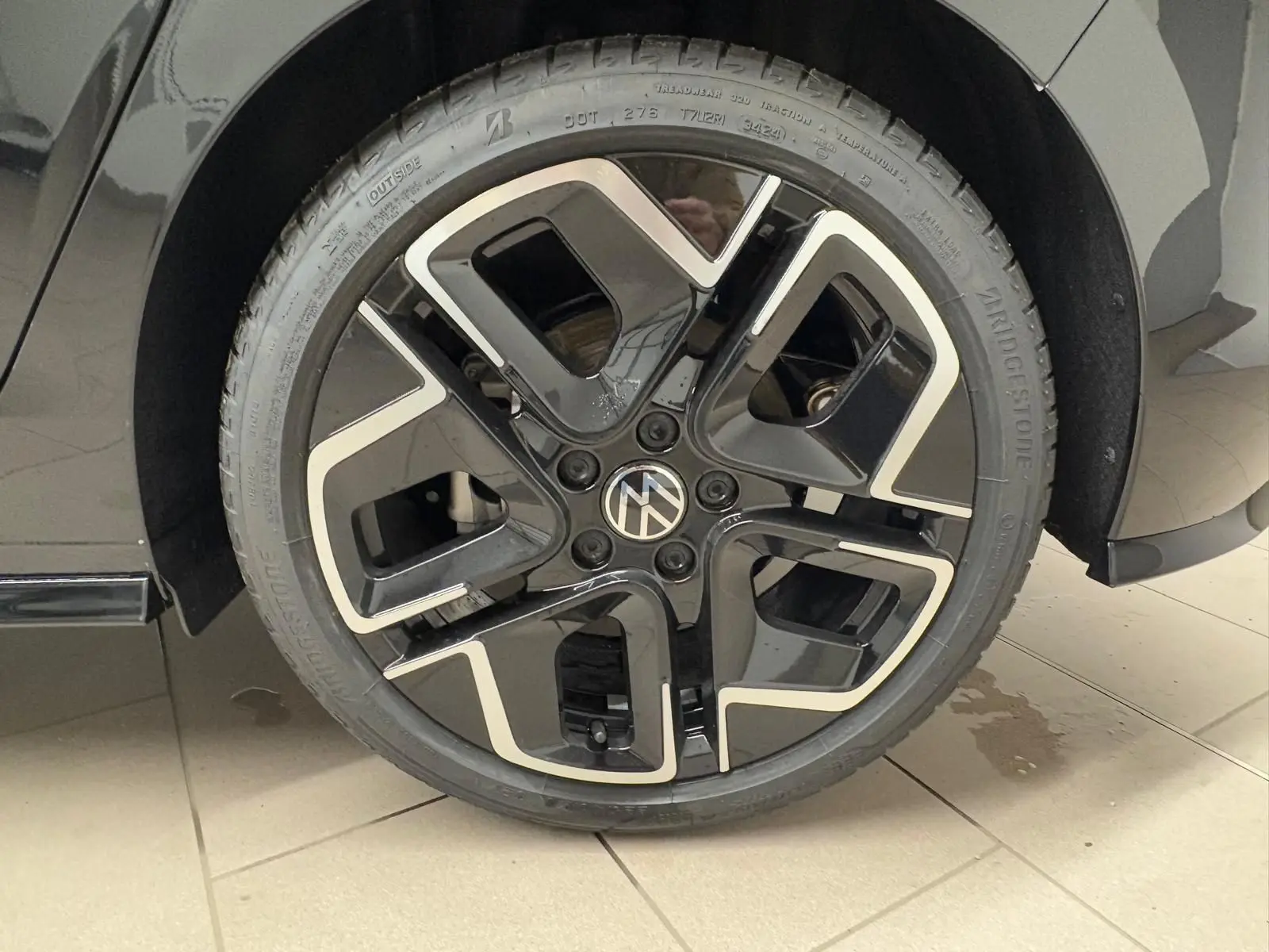 Gros plan sur la roue avant droite noire et argentée de la Volkswagen Golf 2.0 TDI 150 DSG7 R-Line Noir Grenadille.