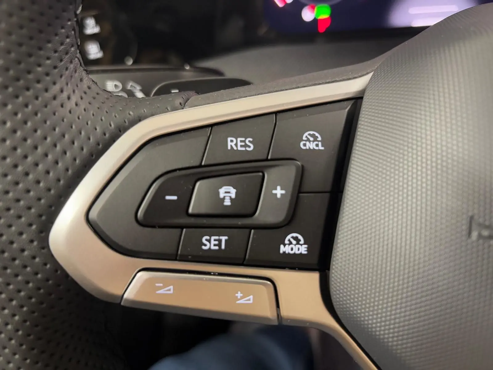 Gros plan sur les commandes du volant multifonction en cuir chauffant de la Volkswagen Golf 2026.