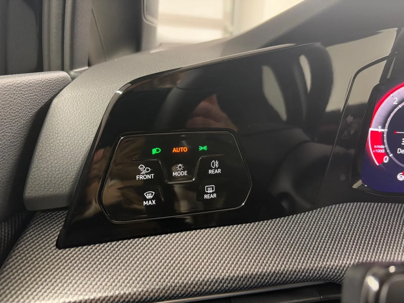 Détail du tableau de bord noir grenadille de la Volkswagen Golf 2.0 TDI 150 DSG7 R-Line avec commandes d’éclairage et mode auto.