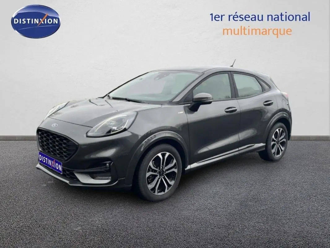 Ford Puma gris foncé en 3/4 avant droit, avec jantes alliage 17 pouces et calandre noire distinctive.