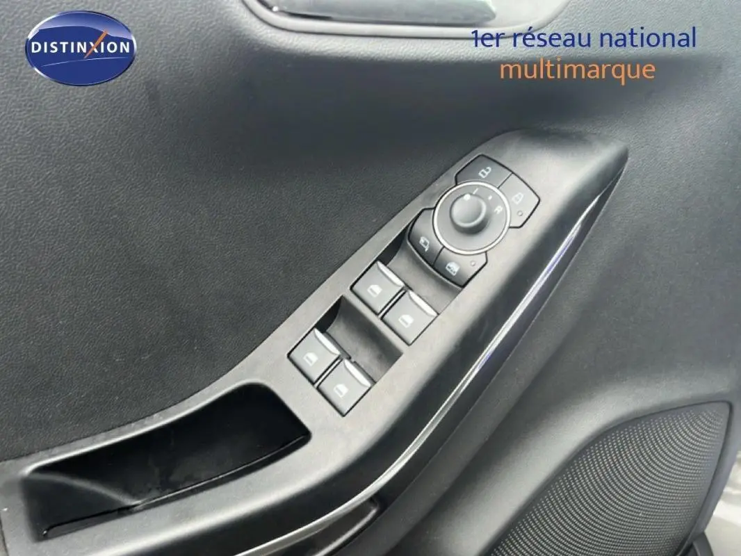 Gros plan sur la commande des vitres électriques et rétroviseurs côté conducteur d’un Ford Puma gris foncé 2024.