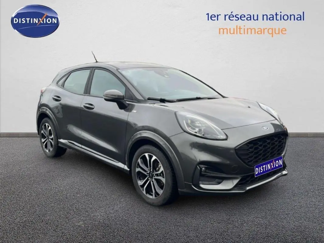 Ford Puma gris foncé vue 3/4 avant droit, avec jantes alliage 17 pouces et calandre noire distinctive.
