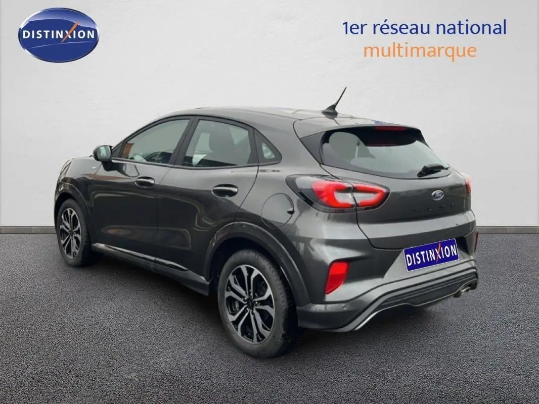 Vue 3/4 arrière droit d'un Ford Puma gris foncé 2024 avec jantes alliage 17 pouces et feux arrière distinctifs.
