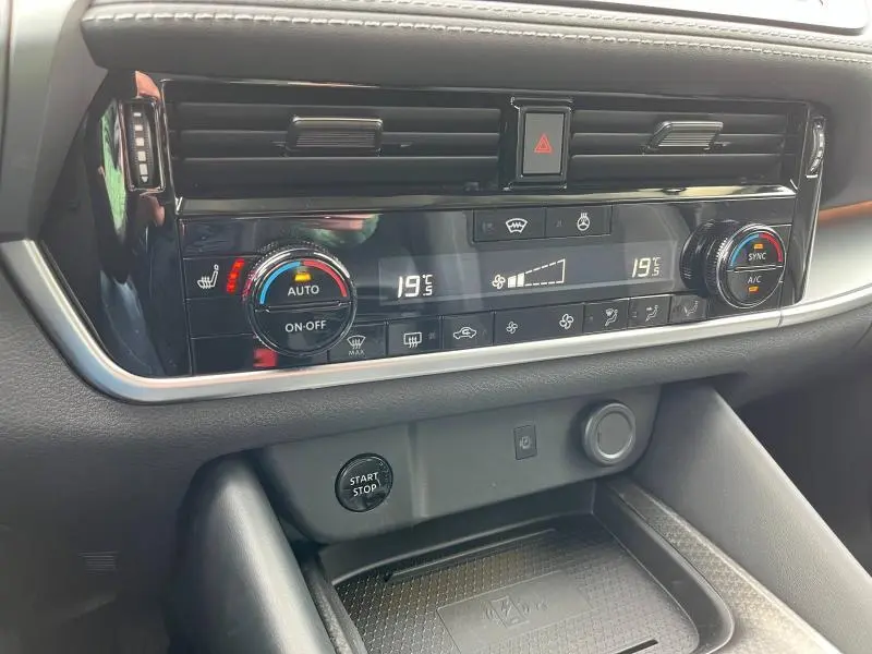 Détail de la console centrale noire du Nissan Qashqai e-POWER 2024 avec commandes climatisation digitale et bouton start/stop visible