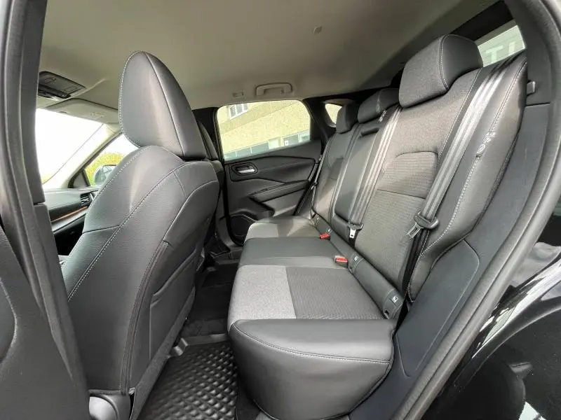 Vue intérieure côté droit sur la banquette arrière mixte cuir et tissu noir du Nissan Qashqai e-POWER 2024.