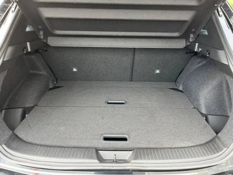 Coffre spacieux du Nissan Qashqai e-POWER 2024, vue intérieure arrière avec plancher modulable en tissu gris foncé.