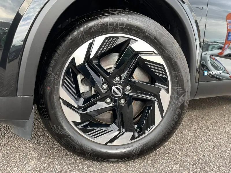 Gros plan sur la jante alliage noire et argentée du Nissan Qashqai e-POWER 2024, avec logo Nissan et badge e-POWER visible sur la carrosserie noire.