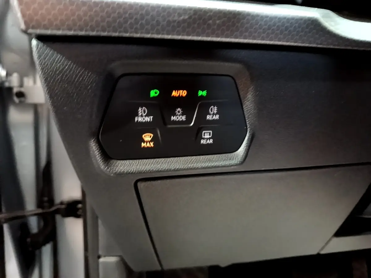 Panneau de commande d’éclairage avec affichage digital dans l’habitacle gris foncé d’une SEAT Leon 2022.