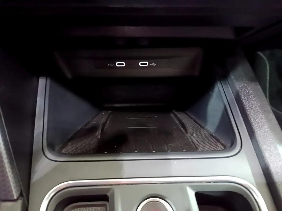 Gros plan sur la zone de recharge à induction et ports USB dans l'habitacle du SEAT Leon gris clair 2022.