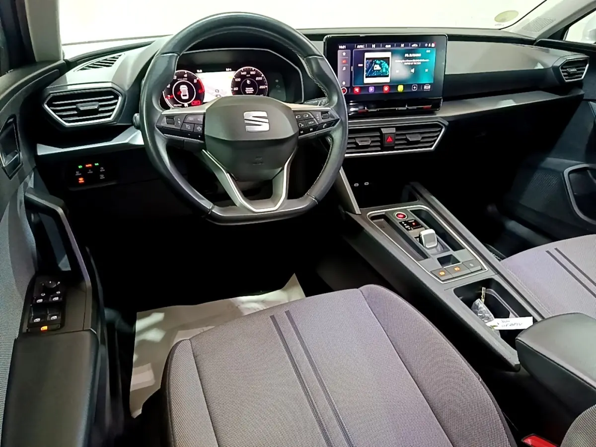 Intérieur avant de la SEAT Leon 2022, tableau de bord moderne avec écran tactile et volant multifonctions noir.