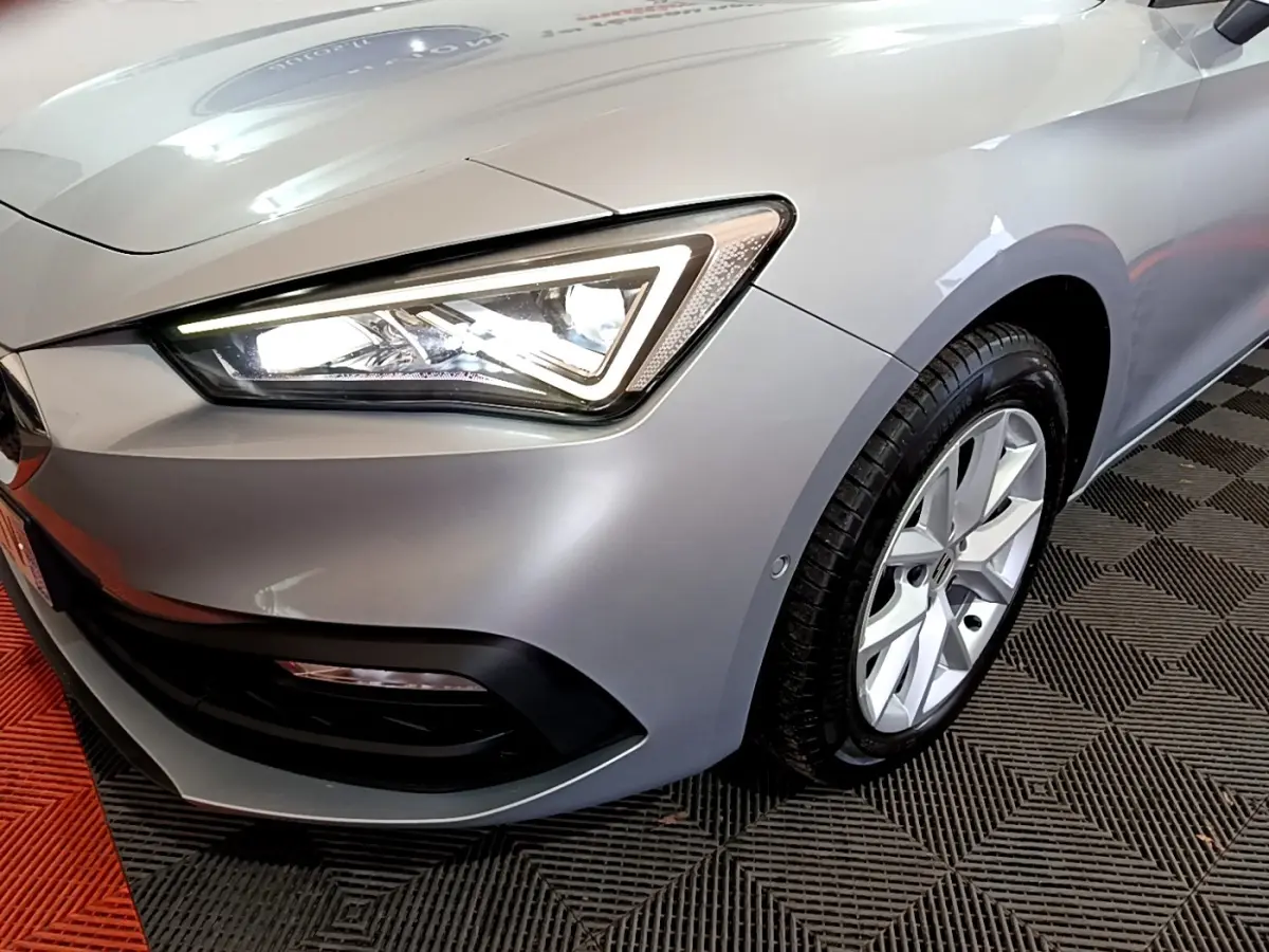 Gros plan sur l'avant droit gris clair d'une SEAT LEON 2022 avec phare LED et jante alliage visible.