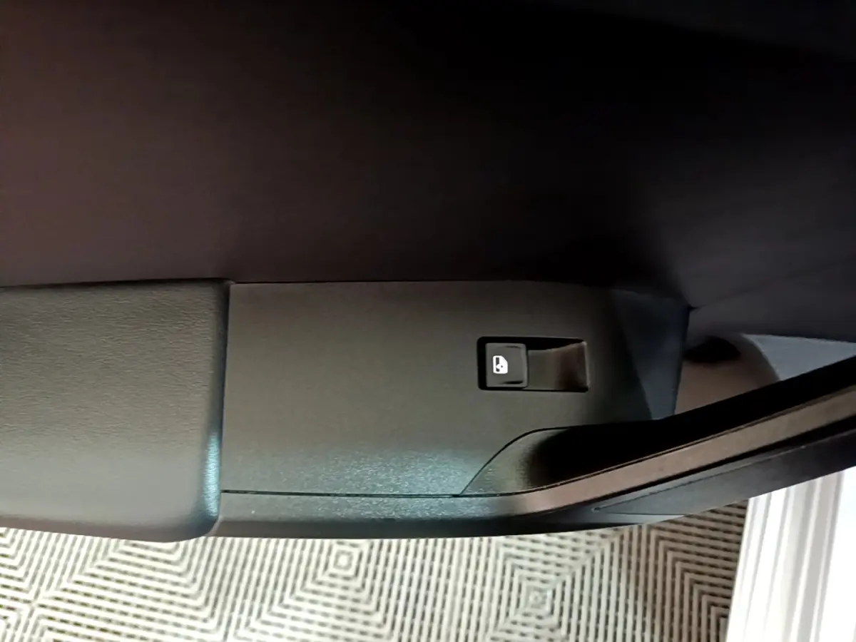 Bouton de déverrouillage intérieur sur la porte côté conducteur d'une SEAT LEON gris clair 2022.